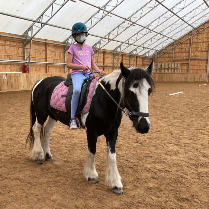 Neve riding a horse named Ruby at Horse SenseAbility in Sherborn, MA, and supported by The Genesis Foundation for Children