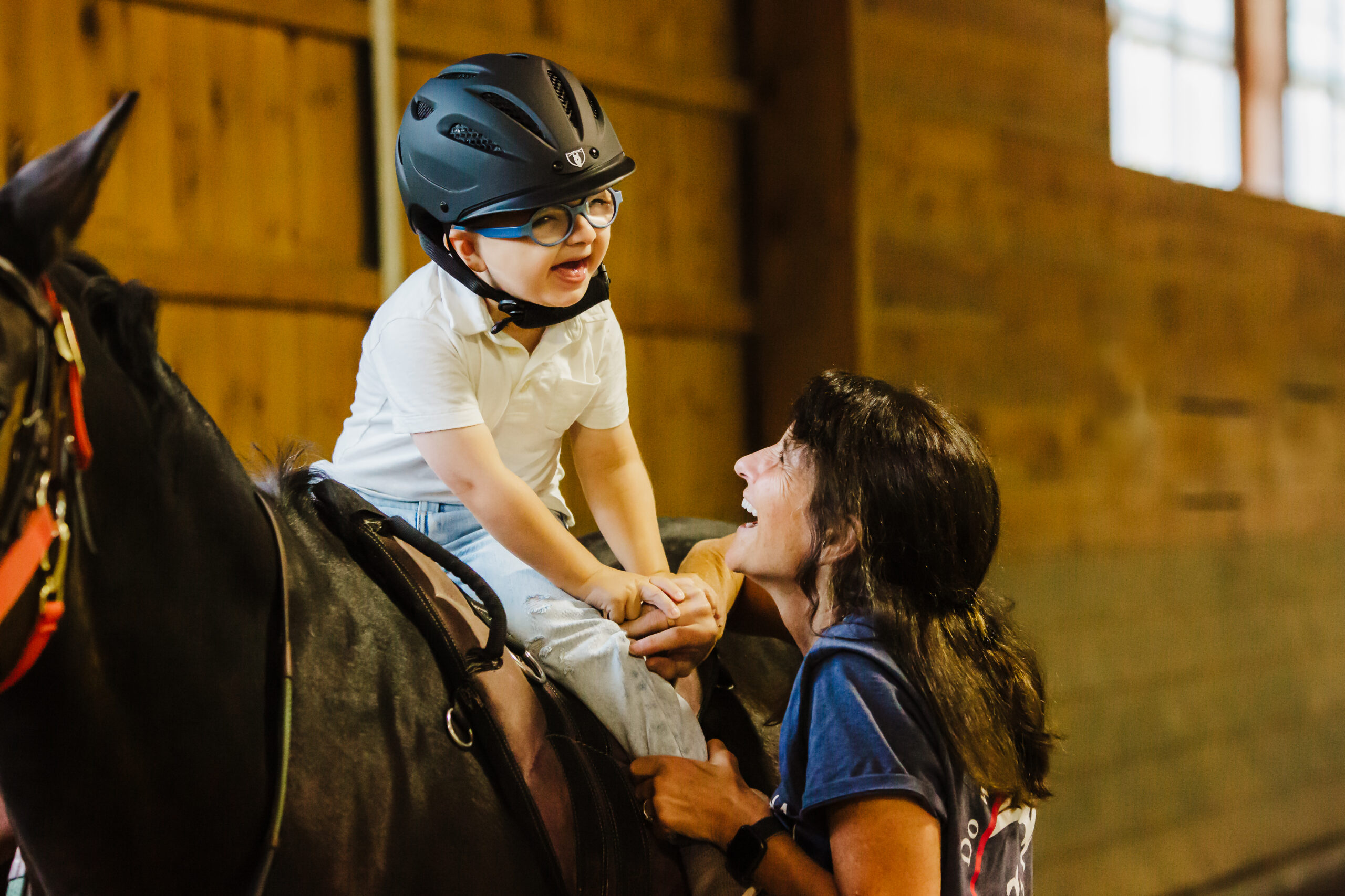 Bradley on a horse and his instructor smiling together